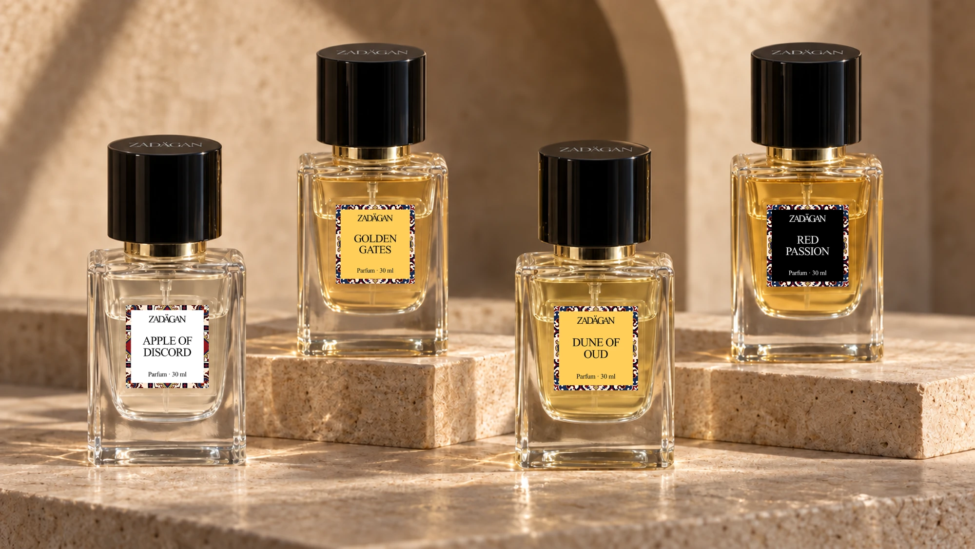 Four ZADÄGAN bottles — Apple of Discord, Golden Gates, Dune of Oud and Red Passion — on sunlit limestone blocks